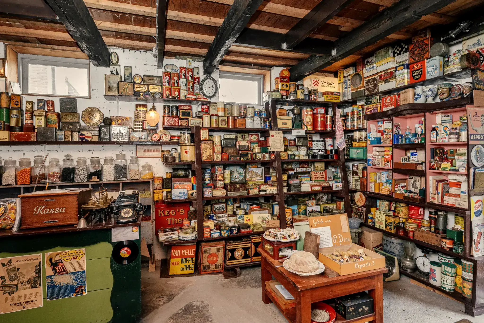 Wand vol oude winkelblikken en nostalgische verpakkingen in Oosterend